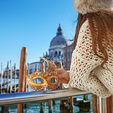 Closeup on Venetian mask in hand of woman in Venice, Italy