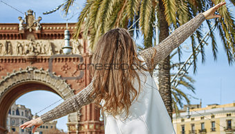 cheerful fashion-monger in Barcelona, Spain walking on parapet