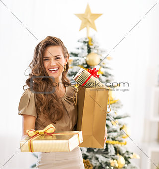 Happy young woman christmas present boxes in front of christmas 