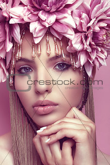 Beautiful woman with flower crown and makeup on pink background