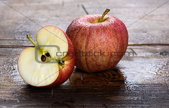 wet fresh red apple on wood background