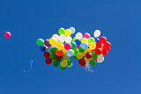 many bright baloons in the blue sky