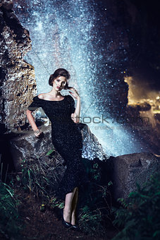 Woman posing near waterfall.
