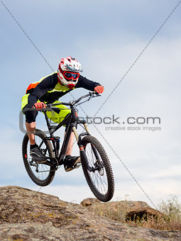 Professional Cyclist Riding the Bike Down Rocky Hill. Extreme Sport Concept.
