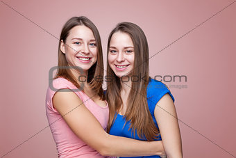 Studio portait of young twin sisters embracing
