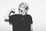 Stylish fashion sexy blonde bad girl in a black t-shirt and rock sunglasses. Dangerous rocky emotional woman.   white toned.  background, not isolated