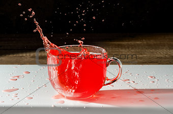 Juice in a Cup and splash with spray on  dark background
