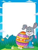 Frame with bunny holding big Easter egg