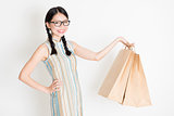 Oriental female holding shopping paper bag