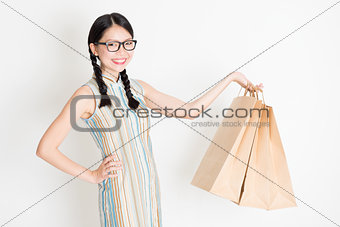 Oriental female holding shopping paper bag