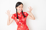 Oriental girl in red qipao surprised