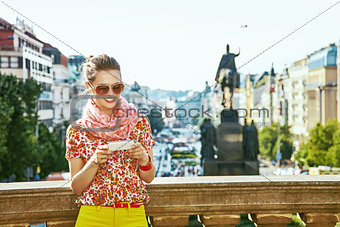 traveller woman on Vaclavske namesti in Prague writing sms