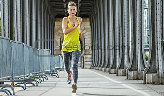 active woman jogging on Pont de Bir-Hakeim bridge in Paris