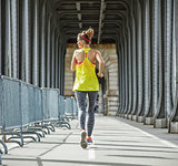 sportswoman jogging on Pont de Bir-Hakeim bridge in Paris