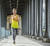 sportswoman jogging on Pont de Bir-Hakeim bridge in Paris