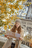 tourist woman on embankment near Eiffel tower looking at map