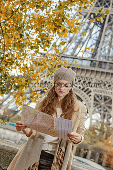 tourist woman on embankment near Eiffel tower looking at map