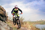 Professional Cyclist Riding the Bike at the Rocky Trail. Extreme Sport Concept. Space for Text.