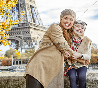 mother and child tourists embracing on embankment in Paris