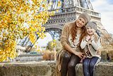 mother and child tourists sitting on the parapet in Paris