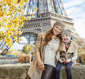 mother and child tourists sitting on the parapet in Paris