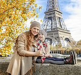 mother and daughter travellers sitting on the parapet in Paris