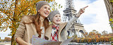 mother and daughter tourists in Paris holding map and pointing