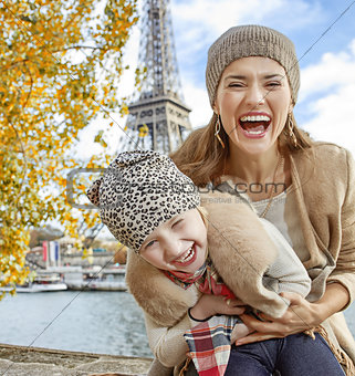mother and child tourists on embankment in Paris having fun time