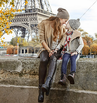 mother and daughter travellers sitting on the parapet in Paris