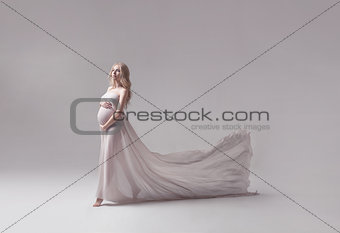 pregnant young woman in flying white dress