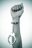 raised fist of a man with a handcuff in his wrist