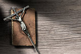 Silver Crucifix and Holy Bible on Wooden Background