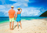 Couple wearing bright clothes on a tropical beach. Mahe, Seychelles