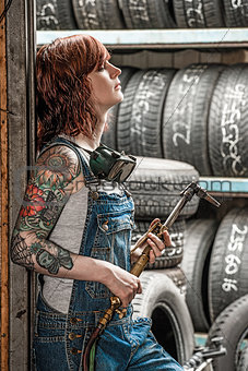 Woman with tattoos holding welding torch