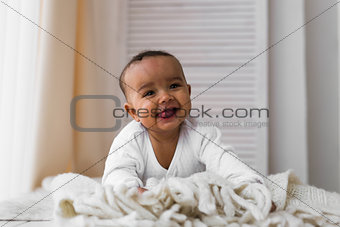 Laughing Mixed Race Baby Boy Lying On Tummy At Home