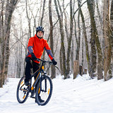 Mountain Biker Resting Bike on the Snowy Trail in Beautiful Winter Forest