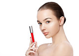 Beautiful girl holding liquid red lipstick