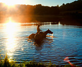 Woman with Two Horses in a Lake at Sunset