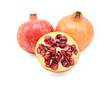 Two pomegranates and a cut half showing seeds