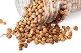 Coriander seeds are poured out from a jar