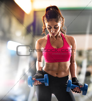 Muscular woman is training at the gym