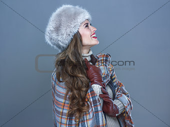 smiling woman isolated on cold blue background looking on copy s