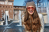 Portrait of happy modern traveller woman in Milan, Italy