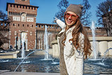 happy traveller woman in Milan, Italy pointing at Sforza Castle