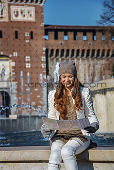 happy woman near Sforza Castle in Milan, Italy looking at map