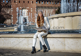 smiling woman near Sforza Castle in Milan, Italy with map