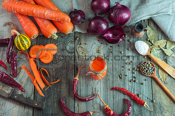 Fresh vegetables and a glass of carrot juice on an old wooden su