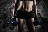 Athletic woman training biceps on grunge background