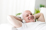 mature man relaxing with music on the sofa