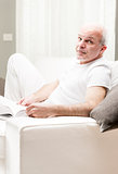man reading a book in his living room